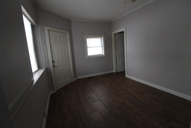 spare room with ornamental molding and dark hardwood / wood-style flooring