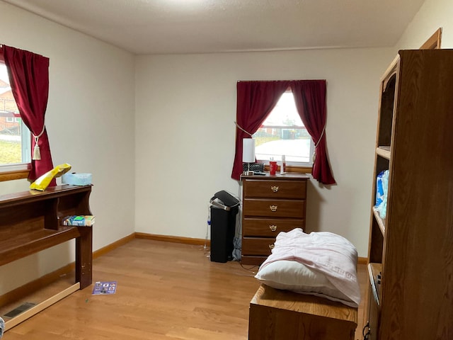 bedroom featuring light hardwood / wood-style floors and multiple windows