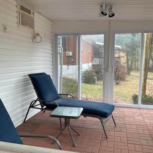 sunroom / solarium featuring a wealth of natural light and a wall unit AC