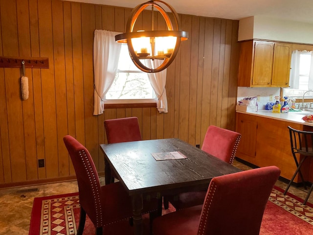 dining room featuring wood walls and a healthy amount of sunlight