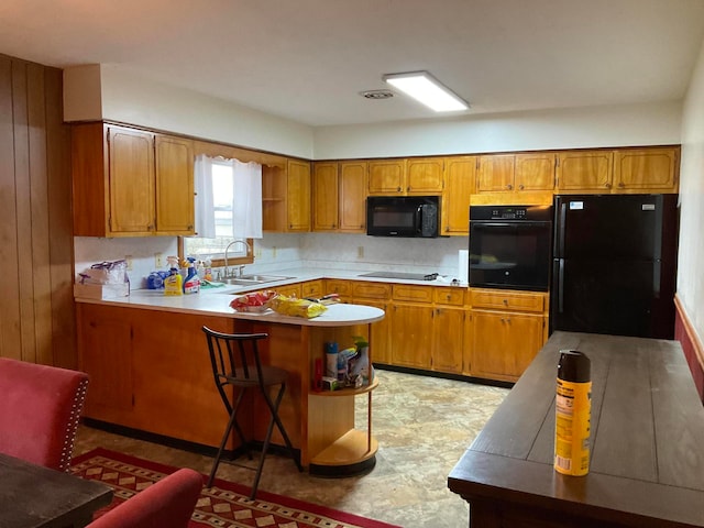 kitchen featuring kitchen peninsula, sink, light tile floors, and black appliances