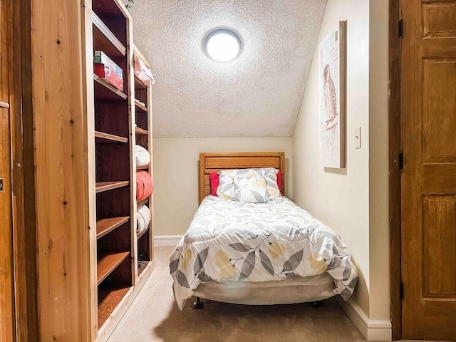 carpeted bedroom featuring vaulted ceiling and a textured ceiling