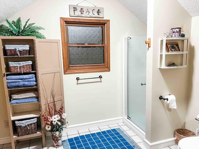 bathroom featuring lofted ceiling, a textured ceiling, toilet, and tile floors