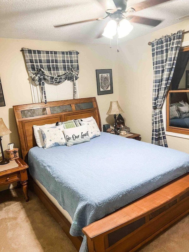 carpeted bedroom with a textured ceiling and ceiling fan