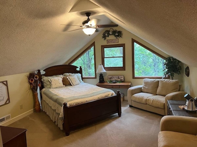 bedroom with ceiling fan, lofted ceiling, a textured ceiling, and light colored carpet