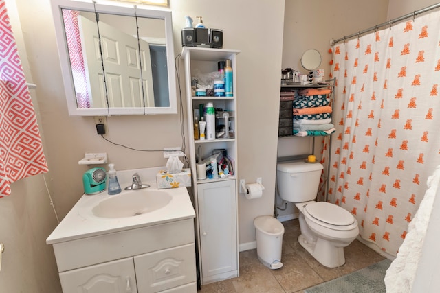 bathroom featuring tile floors, toilet, and vanity with extensive cabinet space