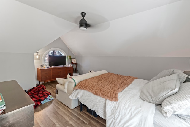 bedroom with ceiling fan, vaulted ceiling, and wood-type flooring