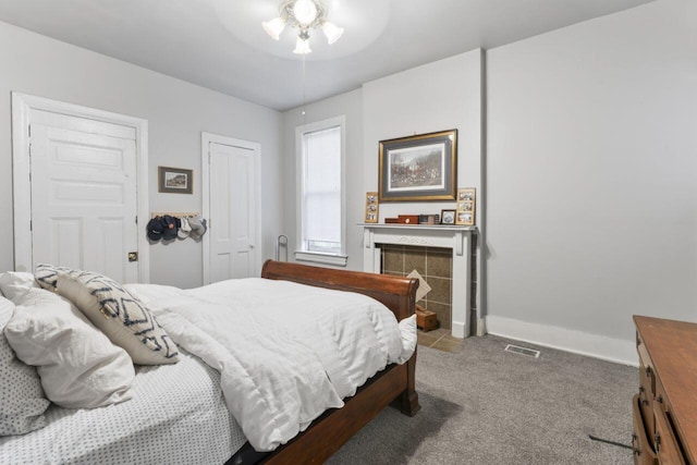 bedroom featuring ceiling fan, carpet floors, and a fireplace