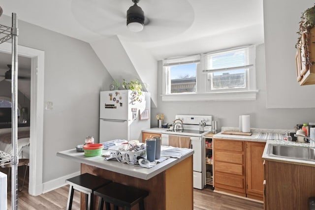 kitchen featuring ceiling fan, white appliances, wood-type flooring, sink, and lofted ceiling