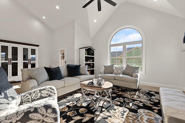 living room featuring wood-type flooring, ceiling fan, and high vaulted ceiling