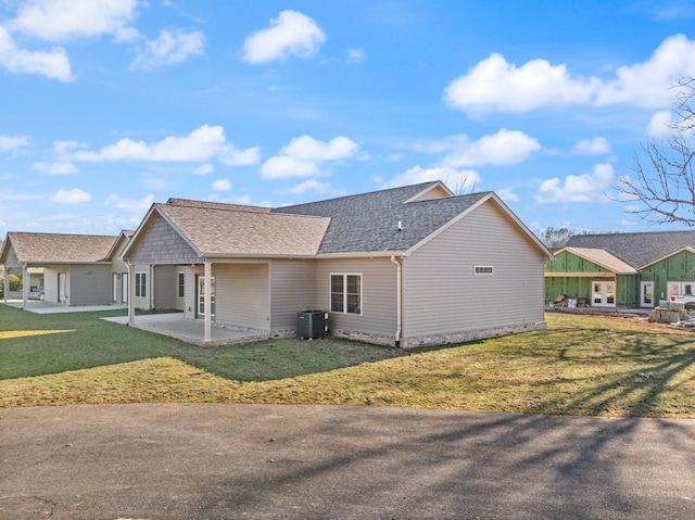 view of side of home with central AC, a lawn, and a patio area