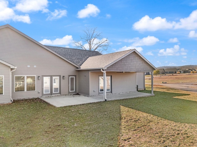 back of property featuring a patio area and a lawn