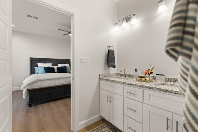 bathroom with hardwood / wood-style flooring, vanity, and ceiling fan