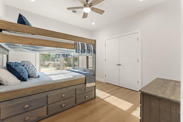 bedroom with light hardwood / wood-style floors, a closet, and ceiling fan