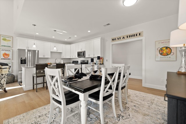 dining area featuring sink and light hardwood / wood-style flooring