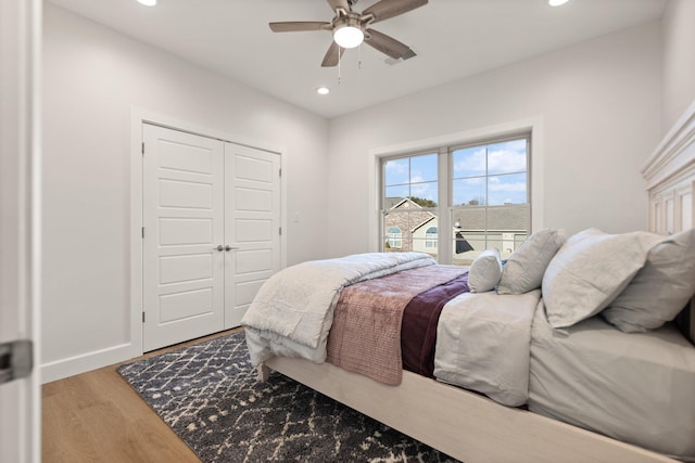 bedroom featuring hardwood / wood-style floors, ceiling fan, and a closet