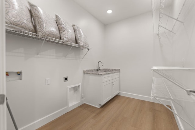 laundry area with sink, cabinets, washer hookup, electric dryer hookup, and light wood-type flooring