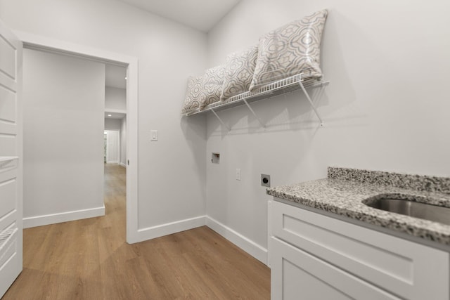 laundry area featuring hookup for an electric dryer, hookup for a washing machine, and light hardwood / wood-style flooring