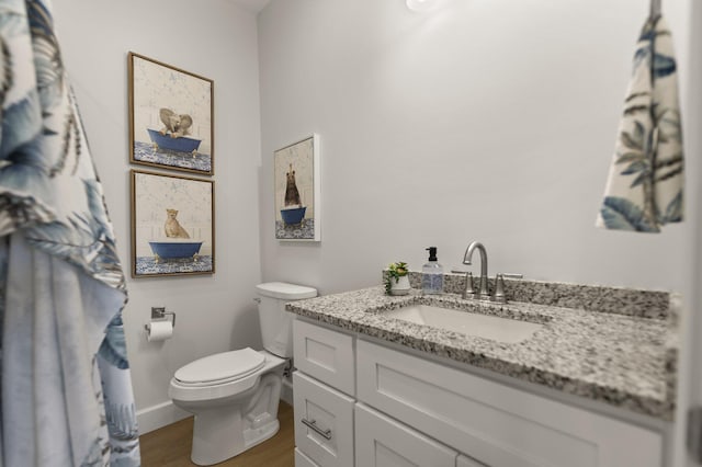 bathroom featuring vanity, hardwood / wood-style floors, and toilet