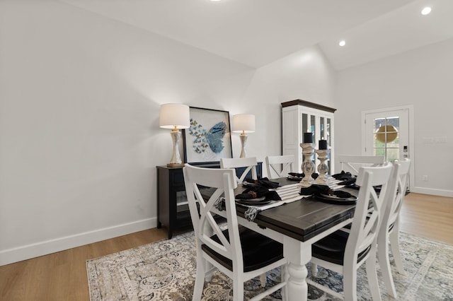 dining area with lofted ceiling and light hardwood / wood-style floors