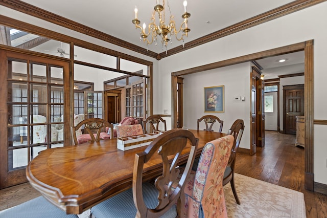 dining room featuring dark hardwood / wood-style floors, crown molding, and a chandelier