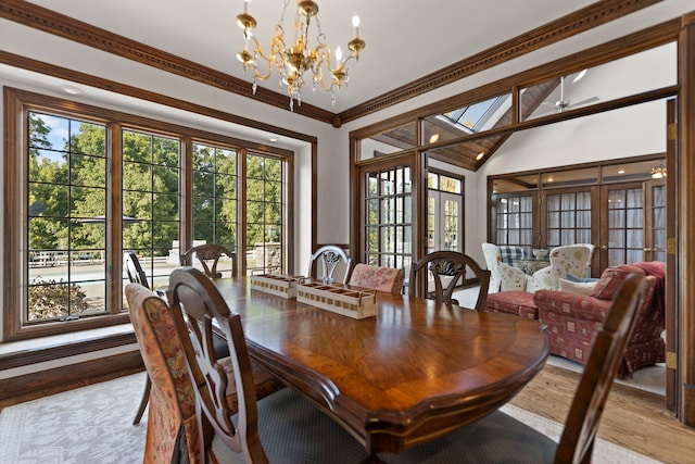 dining room with light hardwood / wood-style flooring, crown molding, a chandelier, and a healthy amount of sunlight