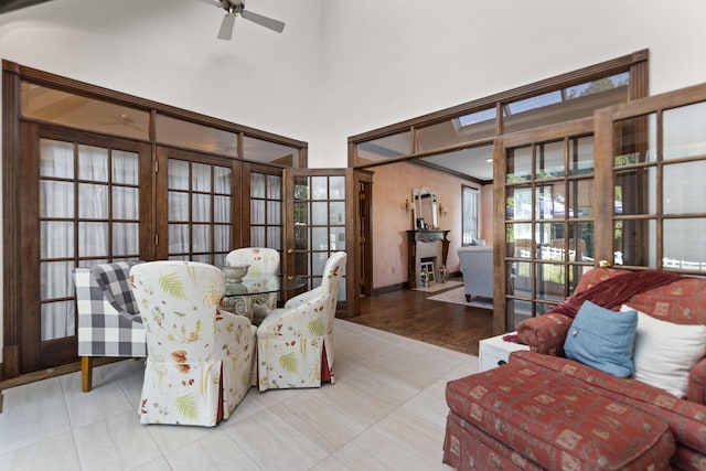 sitting room with ceiling fan, a fireplace, and light hardwood / wood-style floors