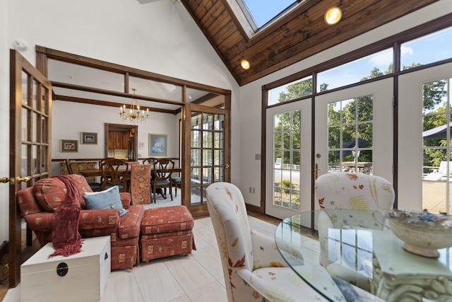 dining room featuring high vaulted ceiling, french doors, light tile patterned flooring, a notable chandelier, and a skylight