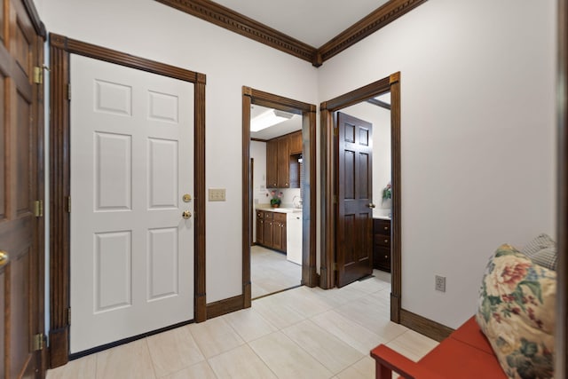 tiled foyer with sink and ornamental molding