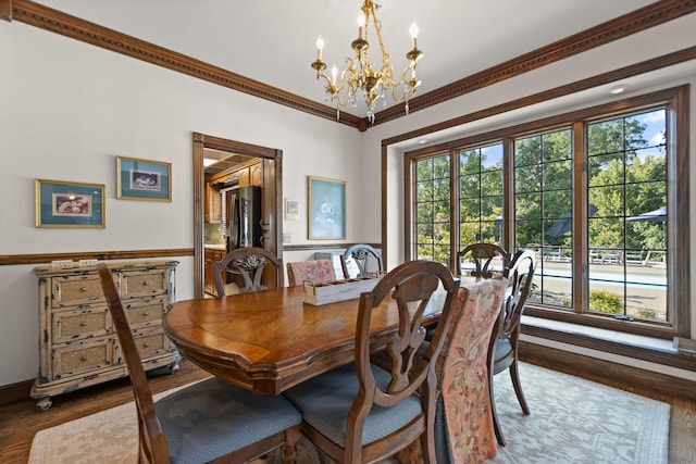 dining space with dark hardwood / wood-style floors, crown molding, and a chandelier