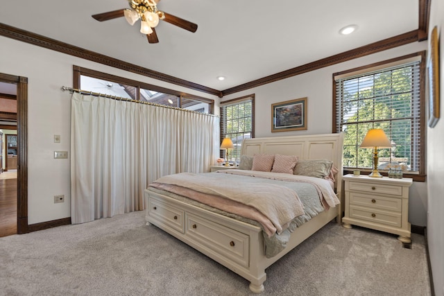 bedroom with crown molding, ceiling fan, and light colored carpet