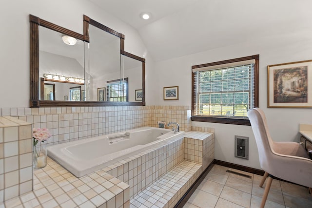 bathroom with tile patterned flooring, heating unit, lofted ceiling, a relaxing tiled tub, and vanity