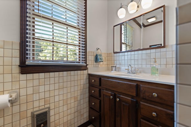 bathroom with tile walls, vanity, and heating unit