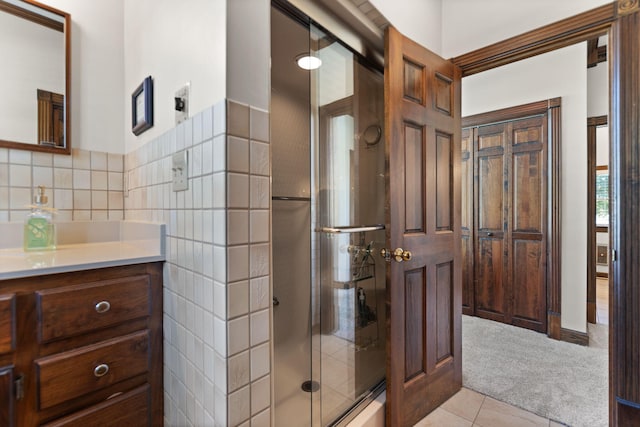 bathroom featuring tile patterned flooring, an enclosed shower, and vanity