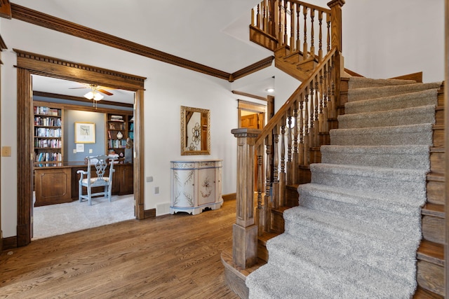 stairway featuring ornamental molding and hardwood / wood-style floors