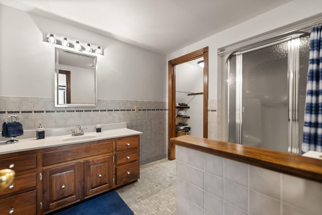 bathroom featuring vanity, tile walls, and a shower with shower door