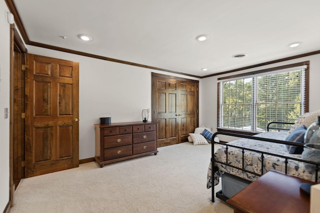 bedroom with ornamental molding and light colored carpet