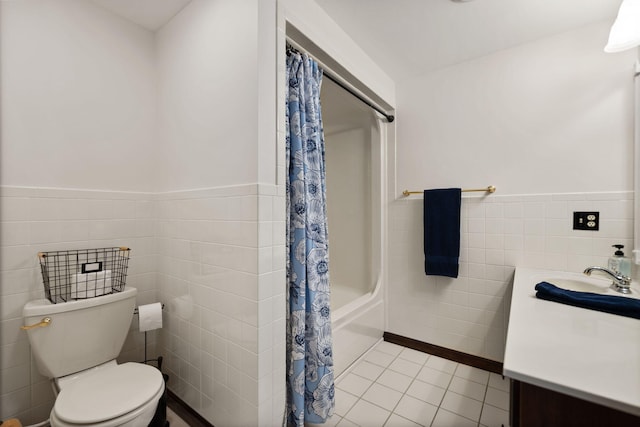 bathroom featuring tile patterned floors, vanity, tile walls, and toilet