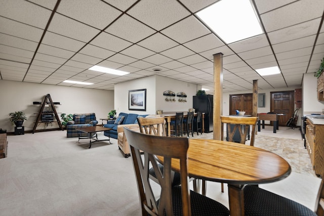 dining room featuring a drop ceiling and light carpet