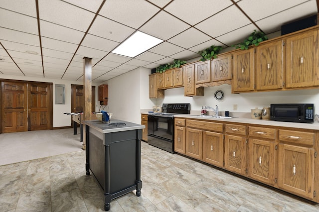 kitchen with a drop ceiling, black appliances, and sink