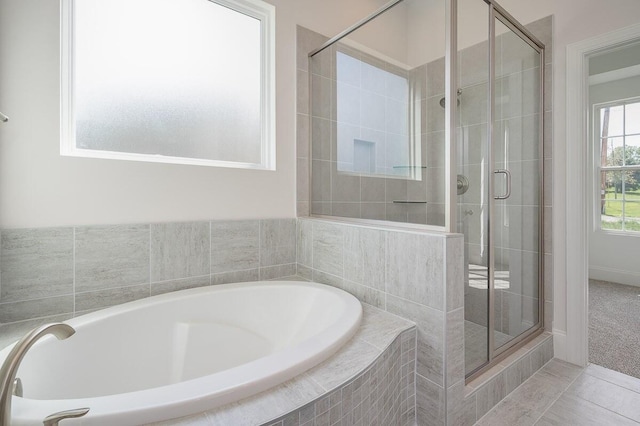 bathroom with shower with separate bathtub and tile floors