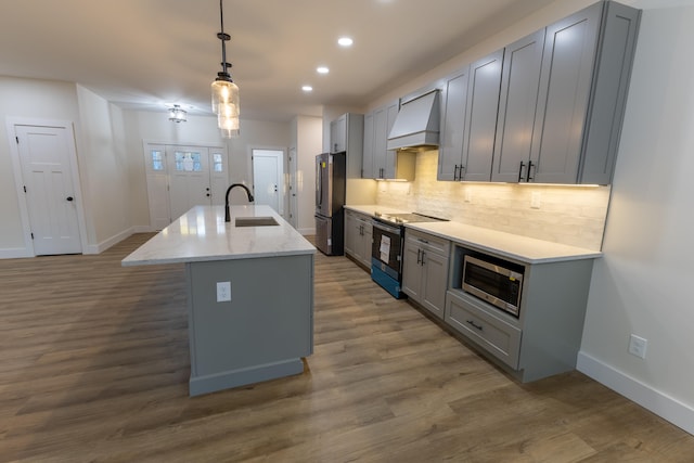 kitchen featuring stainless steel appliances, sink, custom exhaust hood, gray cabinetry, and pendant lighting