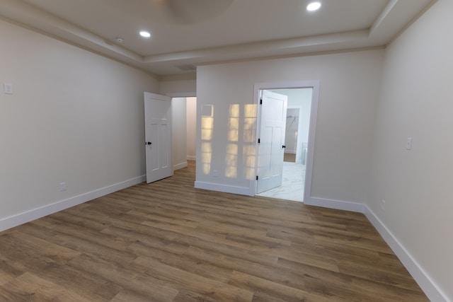 spare room featuring hardwood / wood-style flooring and a tray ceiling