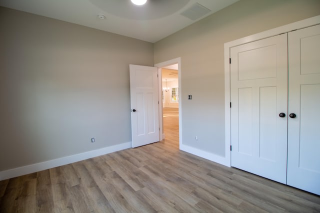 unfurnished bedroom featuring a closet and light hardwood / wood-style floors