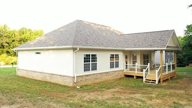 rear view of house featuring a lawn and a porch