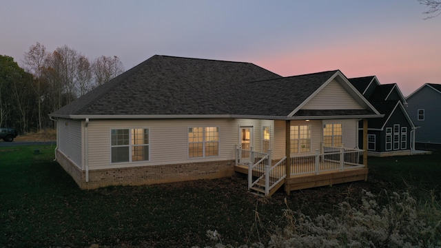 back house at dusk with a wooden deck