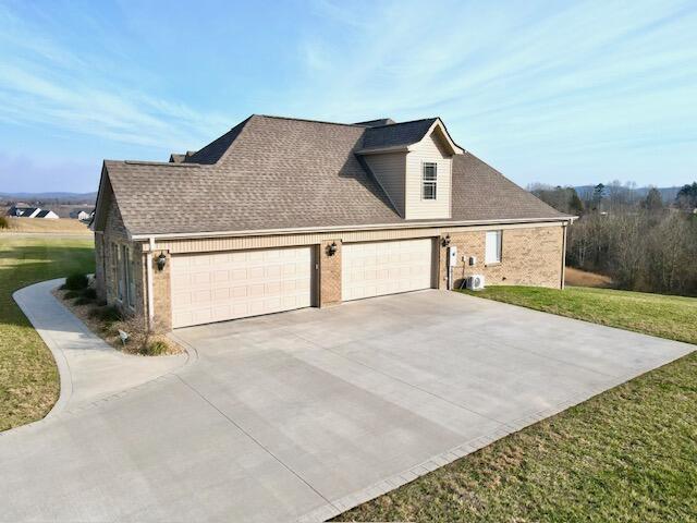 view of side of property with a yard and a garage