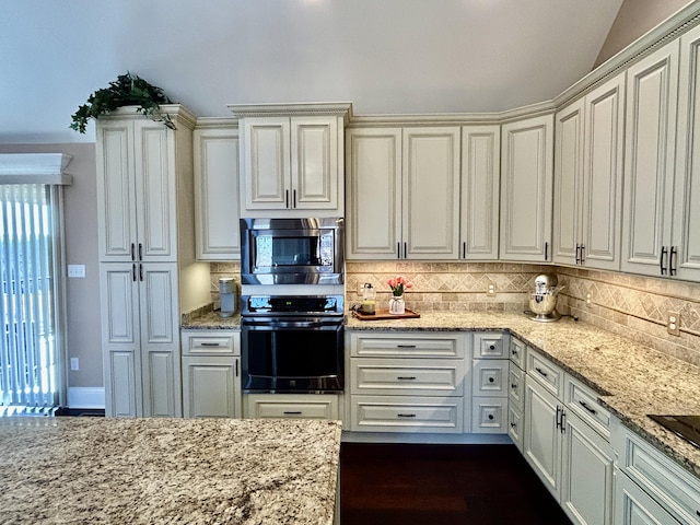 kitchen featuring stainless steel microwave, decorative backsplash, black oven, and light stone countertops