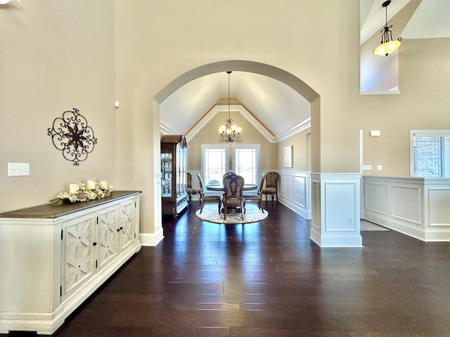 dining space featuring high vaulted ceiling, dark hardwood / wood-style floors, and an inviting chandelier