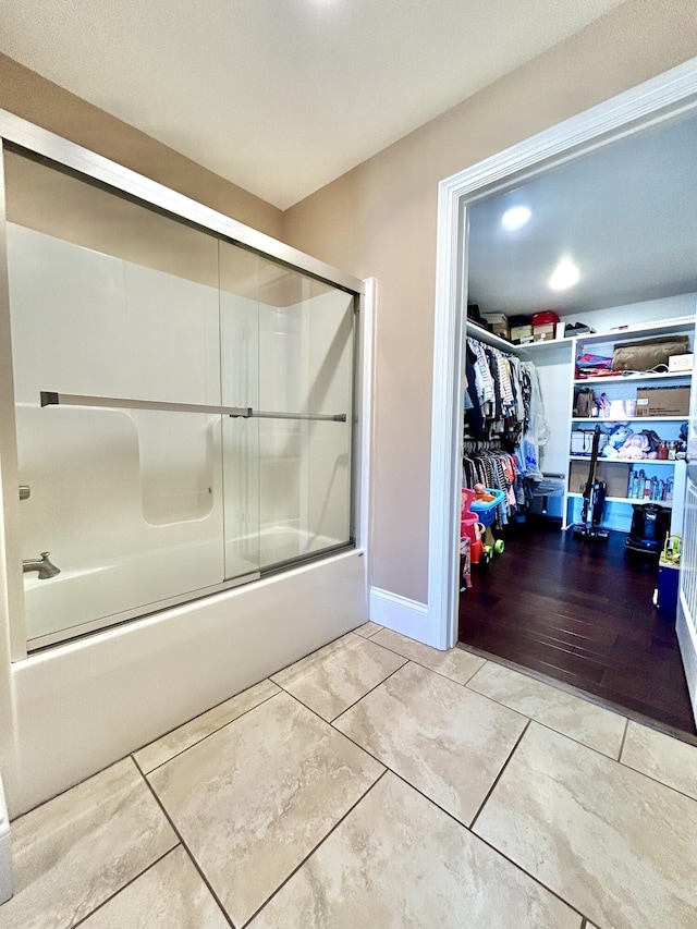 bathroom featuring tile patterned flooring and enclosed tub / shower combo